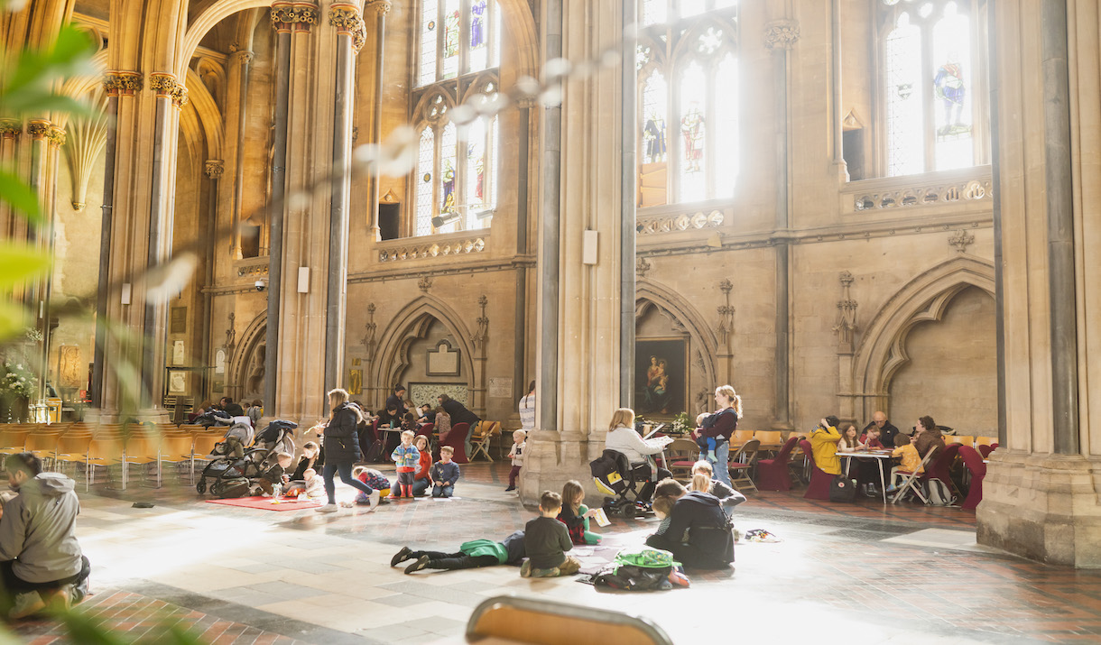 View of the Cathedral Nave filled with families enjoying Crafty Cathedral, children sitting on the floor engaging in crafts.